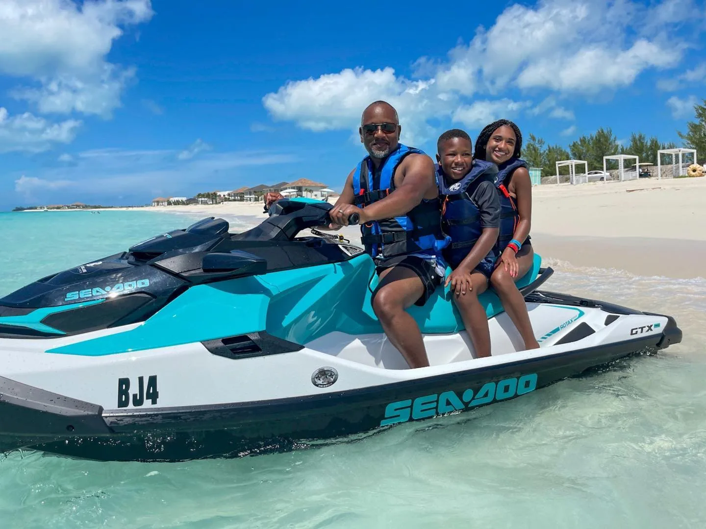Guests on a jet ski in shallow turquoise water