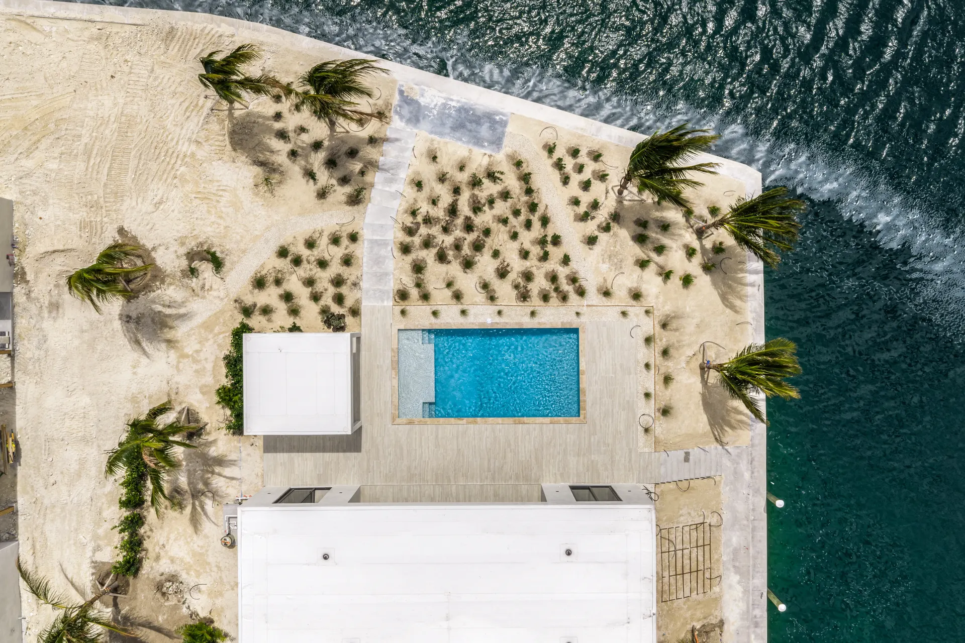 Top-down aerial of an active build site with a pool